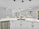 Bright kitchen featuring a large island with seating, modern appliances, white cabinets, and stylish pendant lighting at 23227 Adela Ave, Port Charlotte, FL 33952