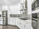 This modern kitchen is equipped with stainless steel appliances, white cabinetry, and an elegant backsplash at 23227 Adela Ave, Port Charlotte, FL 33952
