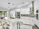 Bright kitchen featuring a large island with seating, modern appliances, white cabinets, and stylish pendant lighting at 23227 Adela Ave, Port Charlotte, FL 33952
