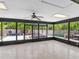 Enclosed lanai with ceiling fan, offering seamless transition to outside deck, a perfect spot for relaxation and entertaining at 23227 Adela Ave, Port Charlotte, FL 33952