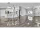 Open-concept living space with modern lighting, high ceilings, and wood-look tile flooring, creating a spacious feel at 23227 Adela Ave, Port Charlotte, FL 33952