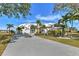 A beautiful white house with a large driveway and well-manicured landscaping evokes an aura of calm and elegance at 24344 Penhollow Ct, Punta Gorda, FL 33955