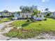 Charming single-story home with a well-maintained lawn, lush palm trees, and canal access at 3000 Wisteria Pl, Punta Gorda, FL 33950