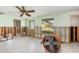Bright living room with a ceiling fan, a large window, and unfinished walls ready for customization at 3000 Wisteria Pl, Punta Gorda, FL 33950
