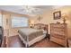 Comfortable bedroom with wood flooring, fan, and large dresser at 9158 Snapper Cir, Port Charlotte, FL 33981