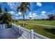 Beautiful backyard view with a green lawn, palms, and a white fence at 1340 San Cristobal Ave # 305, Punta Gorda, FL 33983