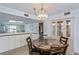 Inviting dining room with a unique chandelier, decorative display cabinet, and views into the kitchen area at 1340 San Cristobal Ave # 305, Punta Gorda, FL 33983