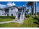 Two-story condo building with white stairs, landscaping, and gray exterior at 1340 San Cristobal Ave # 305, Punta Gorda, FL 33983