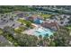 An aerial view of a community center, pool, tennis courts, and lush green landscaping at 14455 Silver Lakes Cir, Port Charlotte, FL 33953