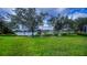 Lush green backyard with mature trees and stunning lake views at 14455 Silver Lakes Cir, Port Charlotte, FL 33953