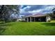Expansive backyard with a well-maintained lawn, mature trees, and a screened-in patio at 14455 Silver Lakes Cir, Port Charlotte, FL 33953
