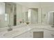 Bright bathroom featuring double sinks, white countertops, vanity, large mirrors, and a separate shower area at 14455 Silver Lakes Cir, Port Charlotte, FL 33953