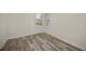 Neutral bedroom with wood-look flooring, base trim and bright natural light from the window at 14455 Silver Lakes Cir, Port Charlotte, FL 33953