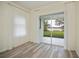 Bedroom with wood-look floors, sliding glass doors to the lanai, and white curtains at 14455 Silver Lakes Cir, Port Charlotte, FL 33953