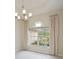 Dining room showcasing a chandelier, large window with natural light, and neutral decor at 14455 Silver Lakes Cir, Port Charlotte, FL 33953