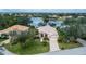 Stunning lakefront home with tile roof, lush landscaping, and a paved driveway at 14455 Silver Lakes Cir, Port Charlotte, FL 33953