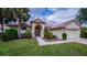 Attractive single-story home featuring a well-kept lawn, arched entryway, and two-car garage at 14455 Silver Lakes Cir, Port Charlotte, FL 33953