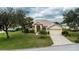 Charming single-Gathering home with a well-manicured lawn and a stone driveway at 14455 Silver Lakes Cir, Port Charlotte, FL 33953
