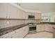 Modern kitchen features light wood cabinets, stainless steel appliances, and tiled backsplash at 14455 Silver Lakes Cir, Port Charlotte, FL 33953