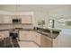 Open kitchen design with granite counters, stainless appliances, and views of the backyard and lake at 14455 Silver Lakes Cir, Port Charlotte, FL 33953
