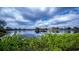 Scenic lake view with surrounding homes and lush green foliage in the foreground at 14455 Silver Lakes Cir, Port Charlotte, FL 33953