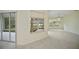 Bright living room featuring a large window with lovely views of the lawn and lake and light wood-look flooring at 14455 Silver Lakes Cir, Port Charlotte, FL 33953