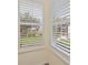Window with white shutters provides a scenic view of a lush backyard and a serene lake at 14455 Silver Lakes Cir, Port Charlotte, FL 33953