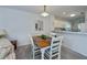 Bright dining area with a wooden table, white chairs, and views of the kitchen and living room at 19335 Water Oak Dr # 202, Port Charlotte, FL 33948