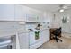 Functional kitchen space featuring white cabinets, an electric stove, and a dedicated work area at 19335 Water Oak Dr # 202, Port Charlotte, FL 33948