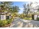 Scenic community entrance featuring tree-lined streets, manicured landscaping, and privacy at 19505 Quesada Ave # Ee204, Port Charlotte, FL 33948