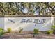 Community sign reading 'The Oaks III & IV Condominium' with manicured landscaping at 19505 Quesada Ave # Ee204, Port Charlotte, FL 33948