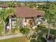 Aerial view of a condo complex featuring lush landscaping, walkways, and a central courtyard at 19505 Quesada Ave # E204, Port Charlotte, FL 33948