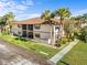 Exterior condo view showcasing a screened lanai, well-kept lawns, and meticulous landscaping at 19505 Quesada Ave # Ee204, Port Charlotte, FL 33948