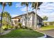 Corner condo unit with neutral paint, green shutters, and mature palms on a sunny day at 19505 Quesada Ave # Ee204, Port Charlotte, FL 33948
