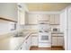 Well-lit kitchen featuring white appliances, cabinets, and laminate countertops, offering a clean and functional space at 19505 Quesada Ave # E204, Port Charlotte, FL 33948