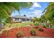 Backyard showcases vibrant landscaping, lush grass, and a screened-in lanai with a lovely garden at 27191 Tierra Del Fuego Cir, Punta Gorda, FL 33983