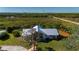 Aerial view of home, highlighting a light-colored metal roof, water access, and greenery at 29175 River Dr, Punta Gorda, FL 33982