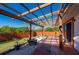 Backyard featuring a wood pergola over a concrete patio with small white stones and lush green bushes at 29175 River Dr, Punta Gorda, FL 33982