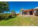 Expansive backyard featuring lush green grass, a wood pergola and privacy fence at 29175 River Dr, Punta Gorda, FL 33982