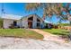Charming exterior view with lush lawn, inviting walkway, and a durable metal roof at 29175 River Dr, Punta Gorda, FL 33982