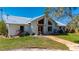 Inviting exterior showcasing a light-filled home with a metal roof and landscaped front yard at 29175 River Dr, Punta Gorda, FL 33982