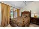 Main bedroom with ceiling fan, ornate furnishings, and sliding glass doors leading to an outdoor area at 29175 River Dr, Punta Gorda, FL 33982