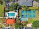 Aerial view of the community pool, pickleball courts, shuffleboard, sand trap and clubhouse surrounded by greenery at 3006 Caring Way # 431, Port Charlotte, FL 33952
