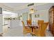 Bright dining area featuring a round glass table with wicker chairs, adjacent to the white kitchen area at 3006 Caring Way # 431, Port Charlotte, FL 33952