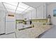 Efficient kitchen with white cabinets, neutral countertops, and modern appliances, ready for easy meal preparation at 3006 Caring Way # 431, Port Charlotte, FL 33952