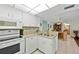 Open kitchen with white appliances, stylish countertops, and a view into the dining area, enhancing connectivity at 3006 Caring Way # 431, Port Charlotte, FL 33952