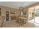 Dining room boasts a wooden table and chairs, modern light fixture, and sliding glass doors to the lanai at 3080 Belleville Ter, North Port, FL 34286