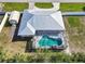 Aerial view of a home with a screened-in pool, metal roof, fenced yard, and additional shed for storage at 4520 Knollwood Dr, Punta Gorda, FL 33982