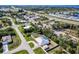 Aerial view of home with a screened pool, shed, fenced yard, and nearby business at 4520 Knollwood Dr, Punta Gorda, FL 33982