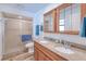 Well-lit bathroom featuring a double vanity, a glass shower, and wood look floors at 4520 Knollwood Dr, Punta Gorda, FL 33982